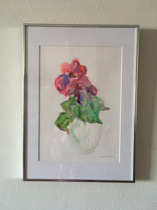 Red flower bursting through leaves and vase 