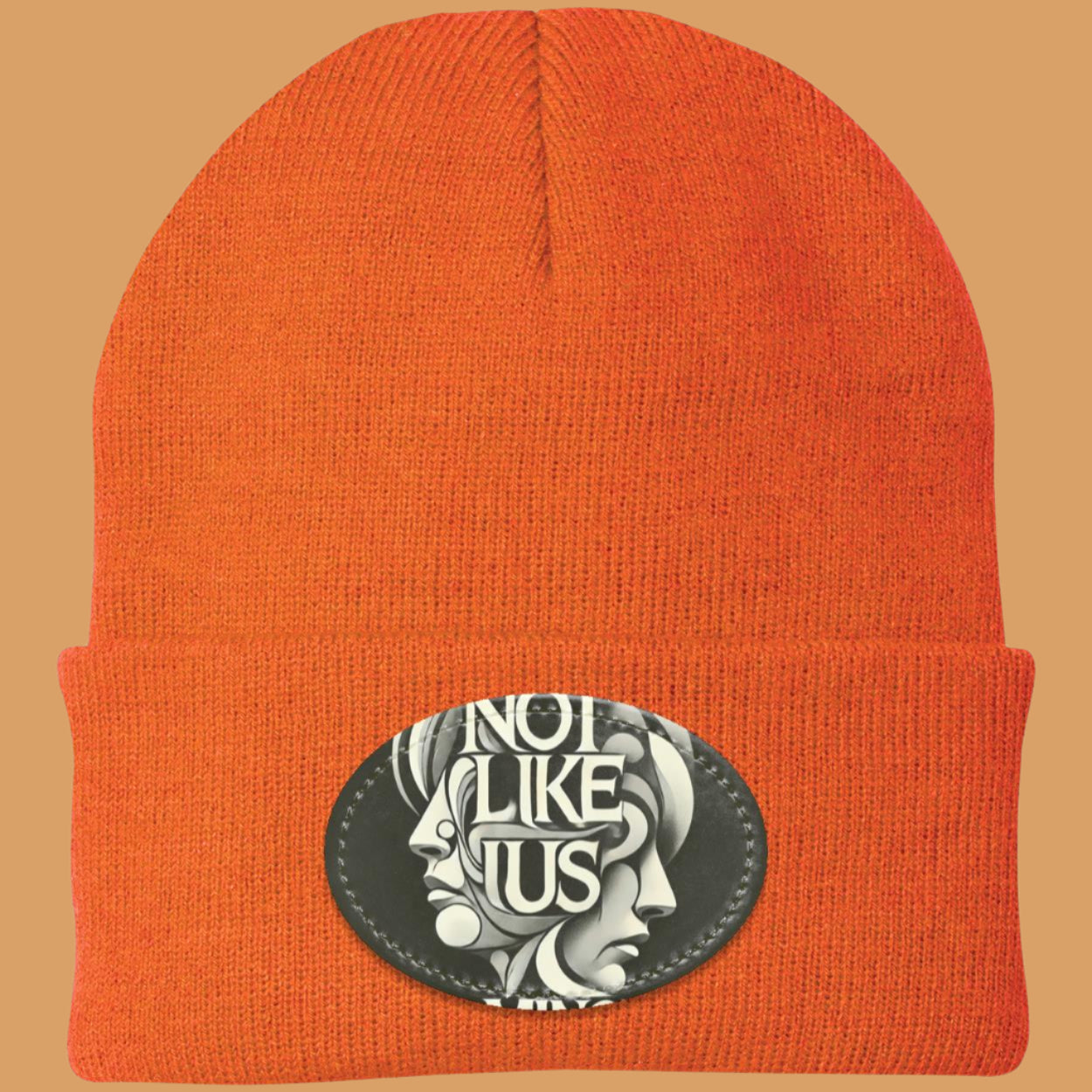 Orange Not like us black beanie with orange rim peach background